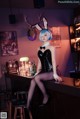 A woman in a bunny costume sitting at a bar.